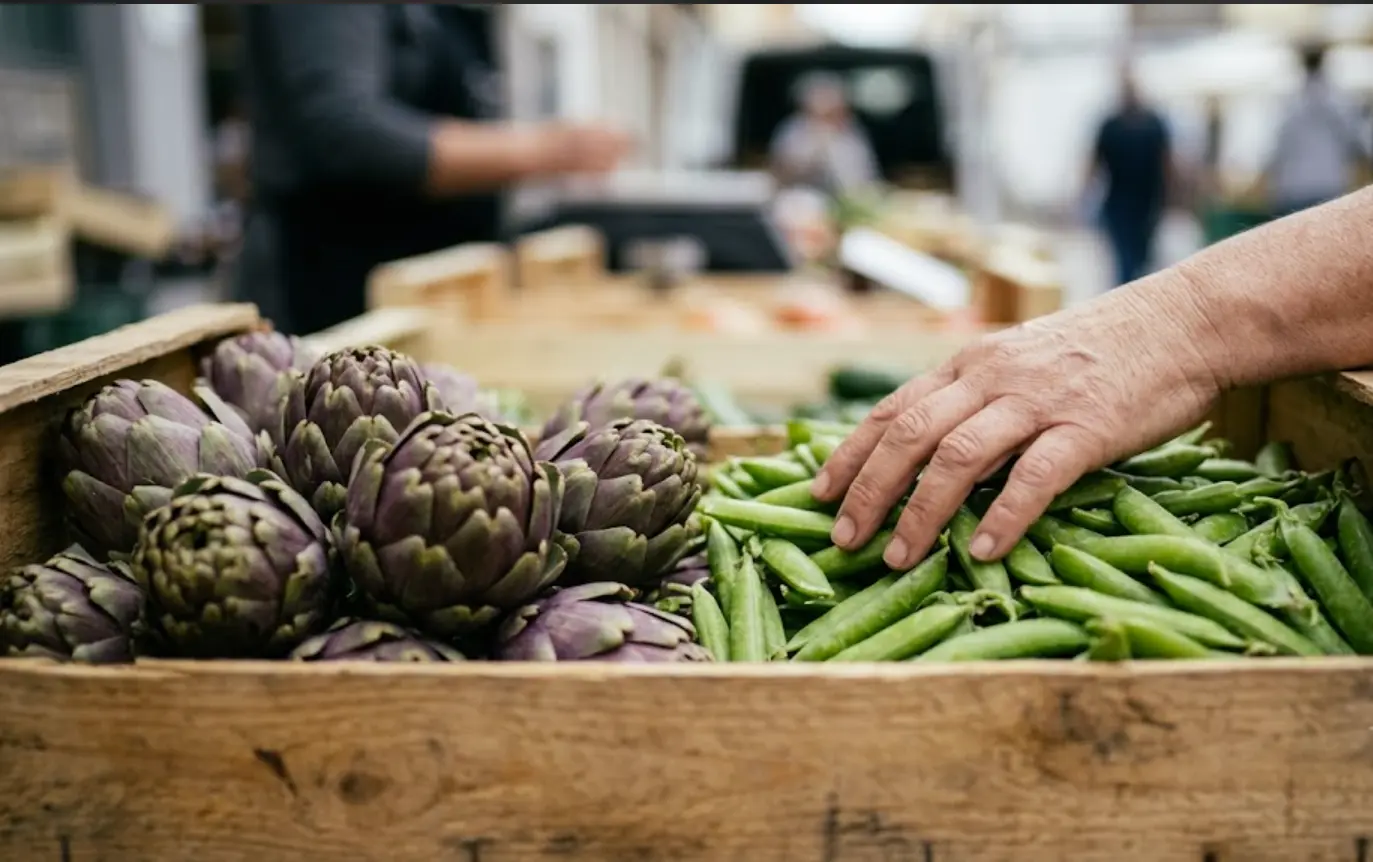 Alcachofas y guisantes frescos de temporada en una frutería de barrio