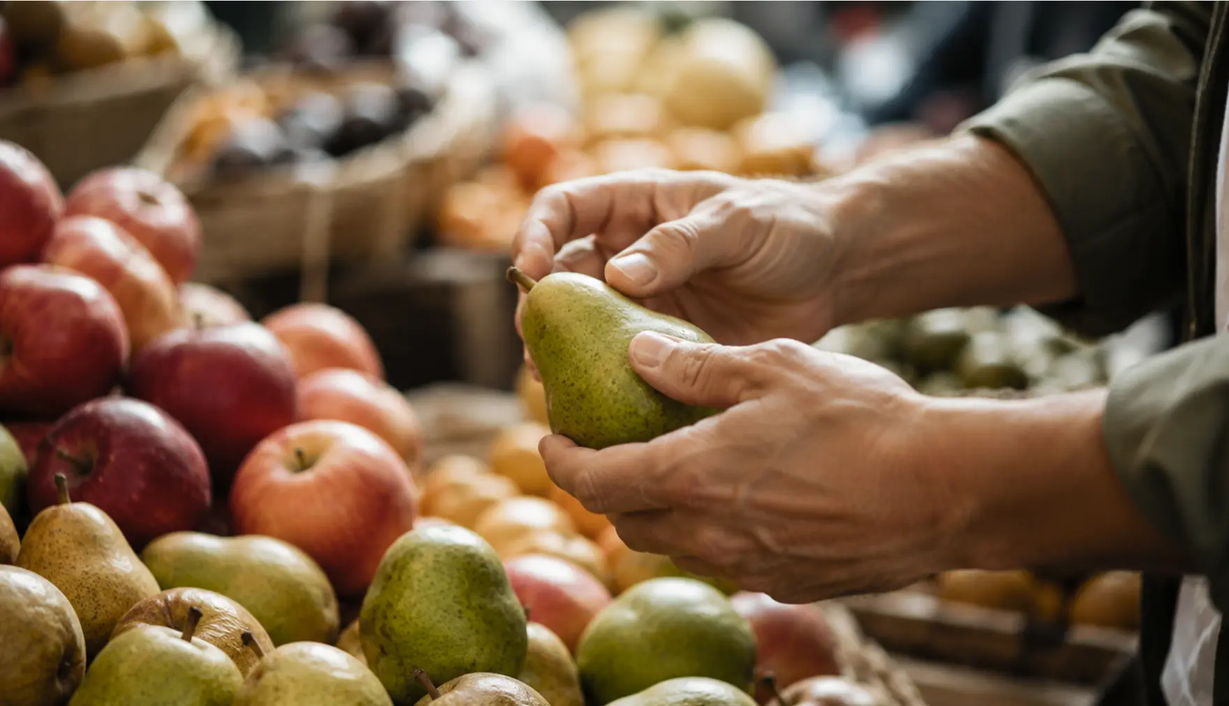 Una mano eligiendo fruta fresca en el mercado, el control que se pierde online